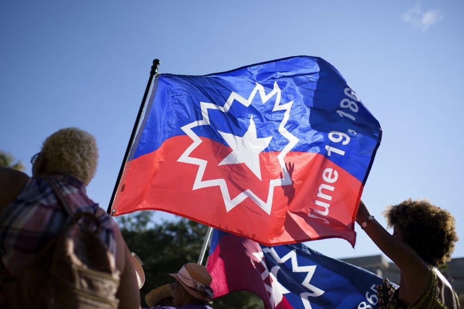 People carry a Juneteenth flag as they march during a re-enactment of the 1865 events in Galveston, Texas.