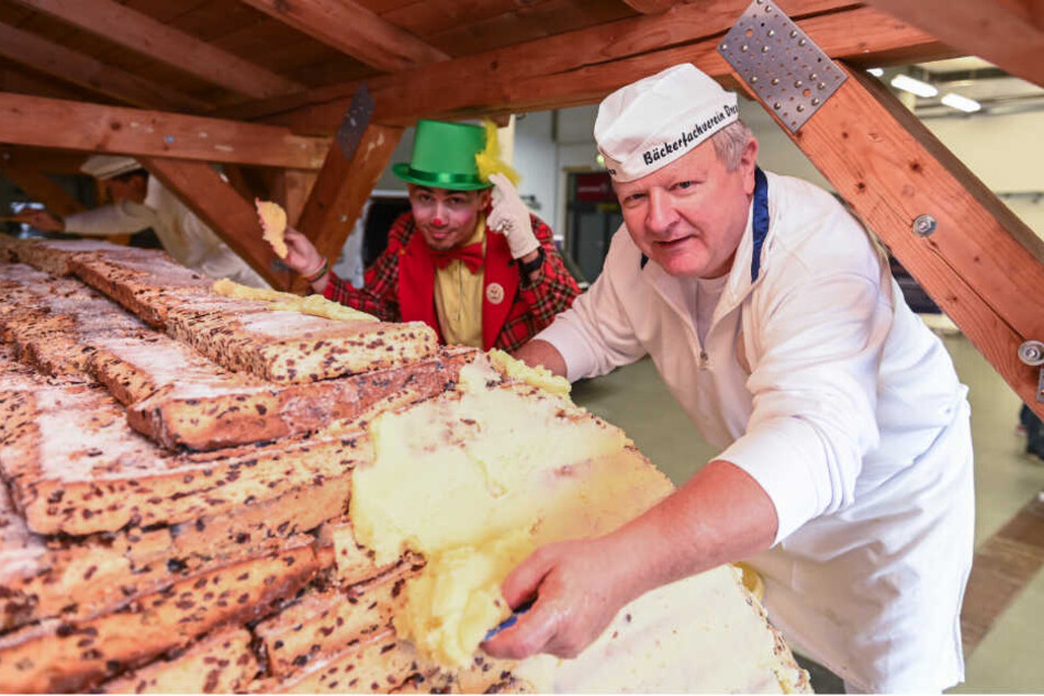 Butter bei die Platten! Bäckermeister Thomas Schmidt (57) schmiert, was das Zeug hält, damit der Riesenstollen eine ordentliche Form bekommt. Tatkräftig unterstützt vom Schabernack eines Clowns vom Dresdner Weihnachts-Circus.
