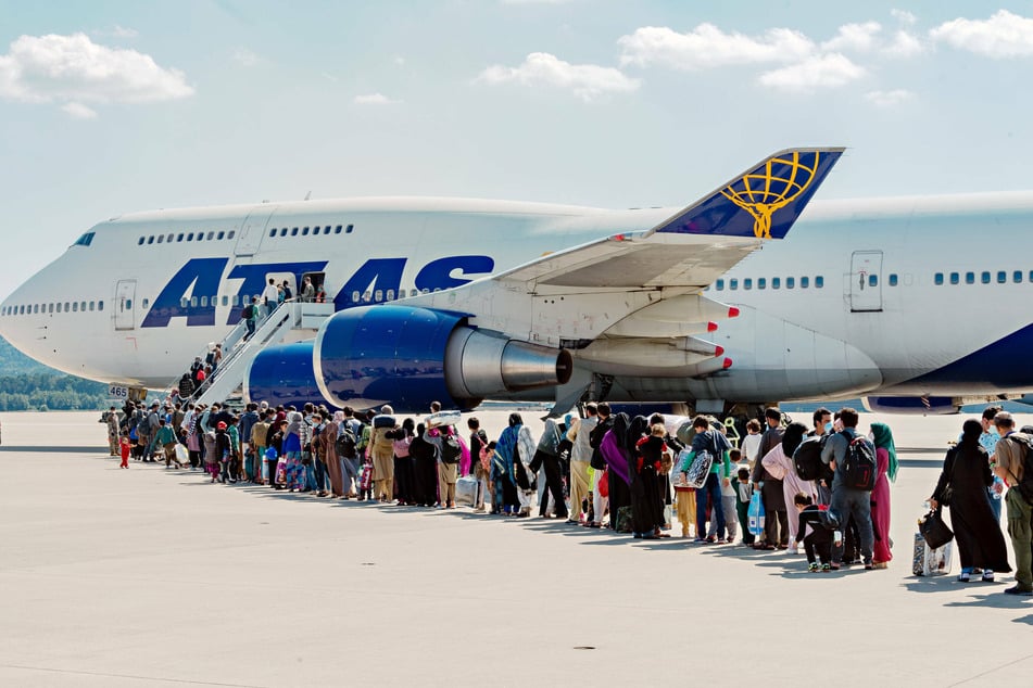 Afghan refugees being evacuated from Kabul board an Atlas Air commercial aircraft for a departure flight from Ramstein Air Base in Germany.