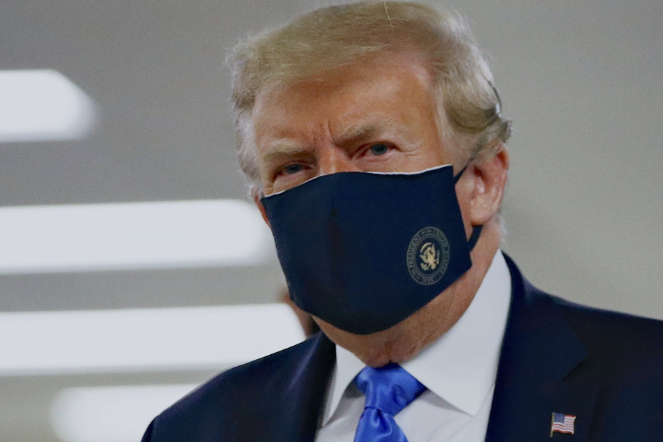 Donald Trump, Präsident der USA, trägt einen Stoff-Mundschutz.