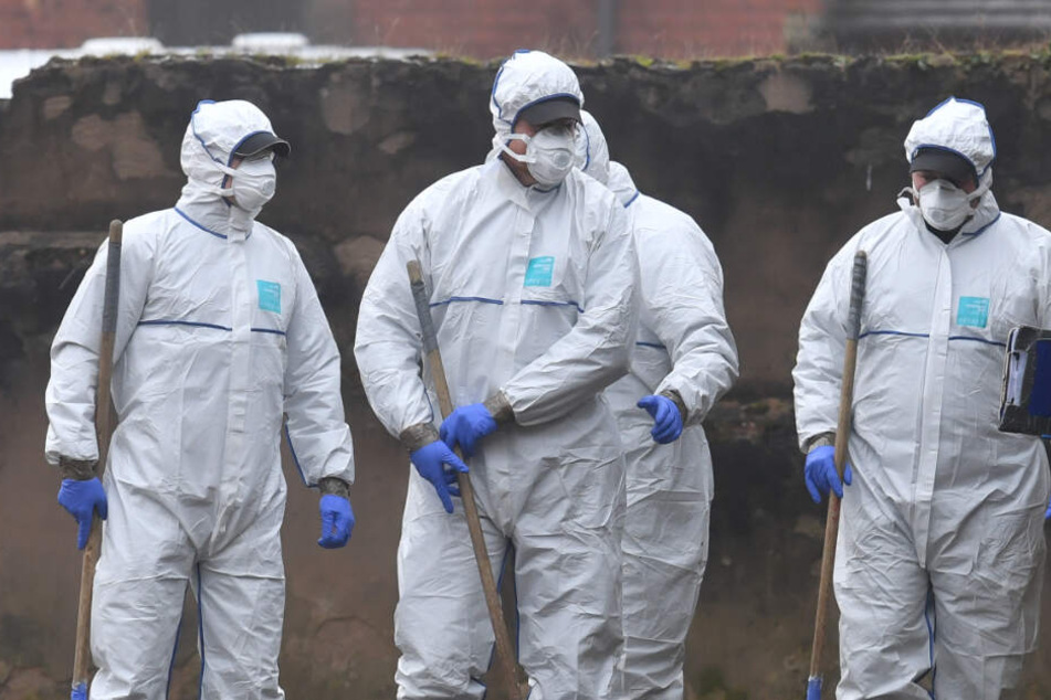 Forensiker nehmen an einer Wohnungsdurchsuchung in einem dreistöckigem Wohnblock teil.