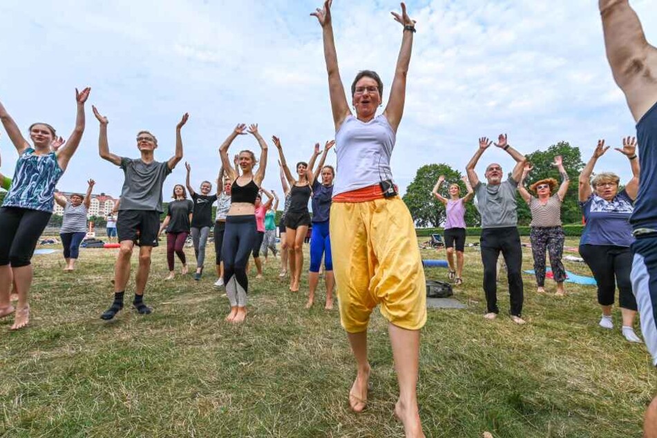 Yoga-Trainerin Katja Durga Lehmann (M..) animiert die Kursteilnehmer zum kollektiven Luftsprung.