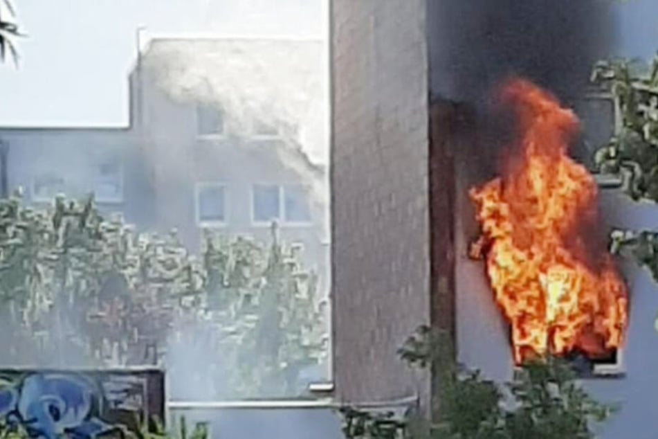 Flammen schlagen aus dem Fenster der brennenden Wohnung in Rostock.
