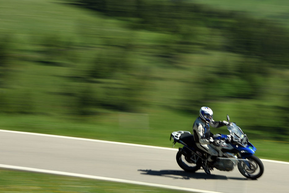 Ein Motorradfahrer fährt mit seiner Maschine auf einer Landstraße (Symbolbild)