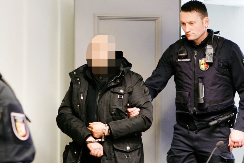 Der Angeklagte wird von einem Justizbeamten in den Gerichtssal des Landgerichts Kiel geführt.