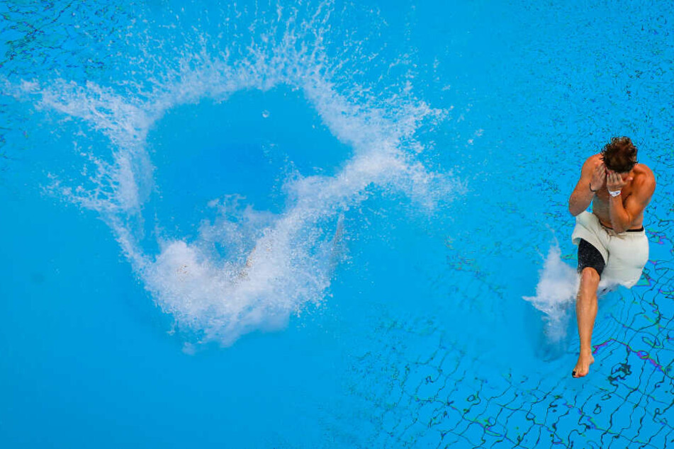 Zwei Teilnehmer der "Arschbomben-Weltmeisterschaft" ("Splashdiving") tauchen beim Finale in das Wasser vom Sprungbecken ein.