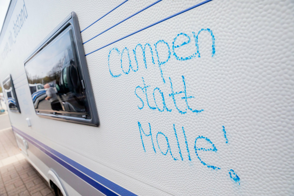 "Campen statt Malle!" steht vor dem Start eines Camper-Korsos der Camperinitiative "Campen mit Abstand" am Olympiastadion auf einem Wohnwagen.