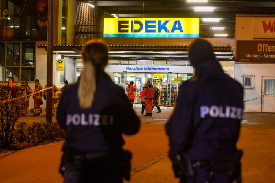 Polizisten stehen vor einem Edeka-Supermarkt, vor dem Schüsse gefallen sind.