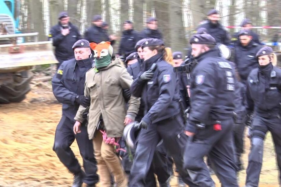 Hier wird der verdächtige Mann von der Polizei abgeführt.