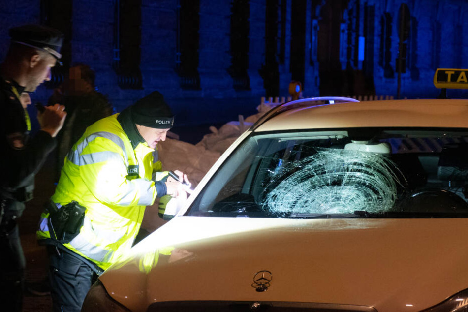 Polizisten untersuchen das Unfall-Auto.