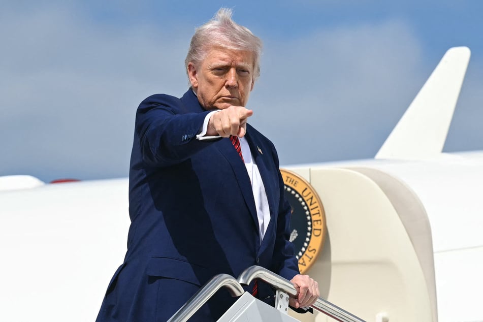 US President Donald Trump points as he boards Air Force One prior to departure from Joint Base Andrews in Maryland on Friday, as he travels to New Jersey for the weekend.