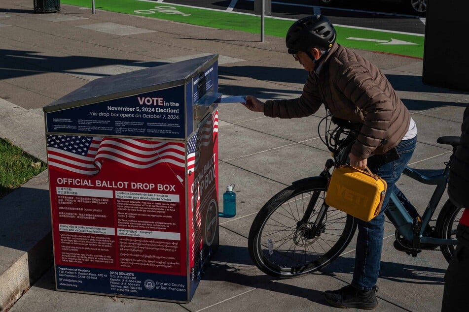 A voter drops off ballots at an official ballot drop box on Election Eve in San Francisco, California.