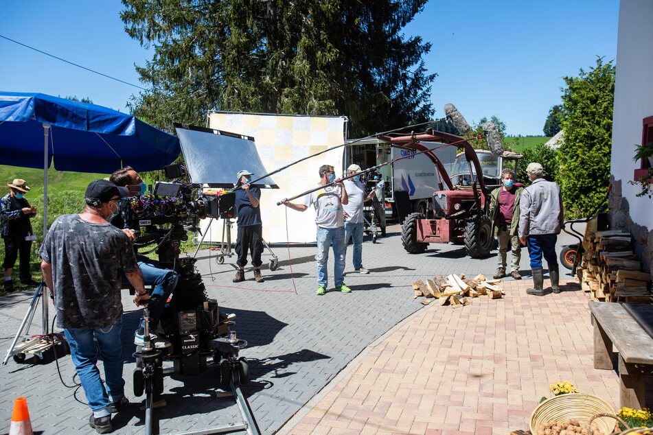 Schauspieler und Filmcrew proben am Filmset und tragen dabei Mund-Nasen-Masken.