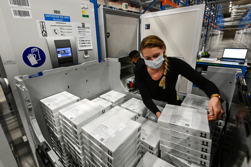 Belgien, Puurs: Mitarbeiter sortieren Pakete in Kühlschränke, in denen der Corona-Impfstoff von Biontech/Pfizer gelagert wird.