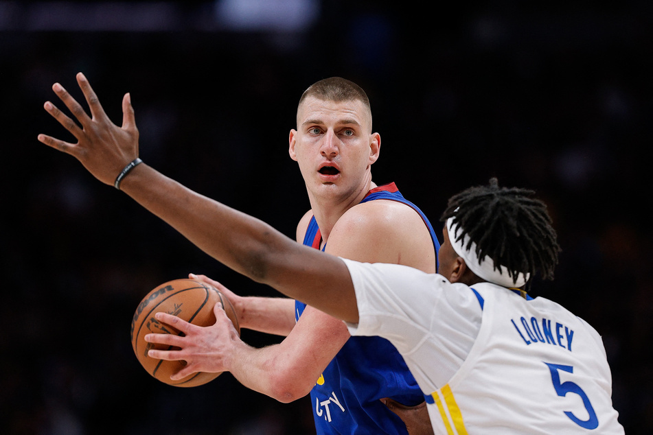 Denver Nuggets center Nikola Jokić (15) controls the ball as Golden State Warriors center Kevon Looney (5) guards in the first quarter during game three of the first round for the 2022 NBA playoffs at Ball Arena.