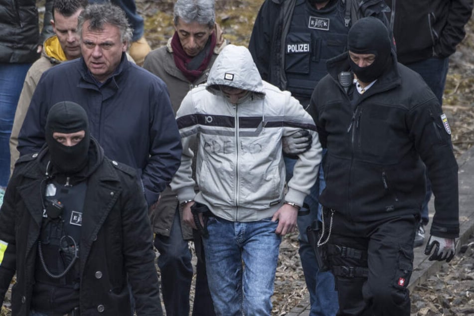 Ali B. wird in Handschellen zum Tatort geführt.
