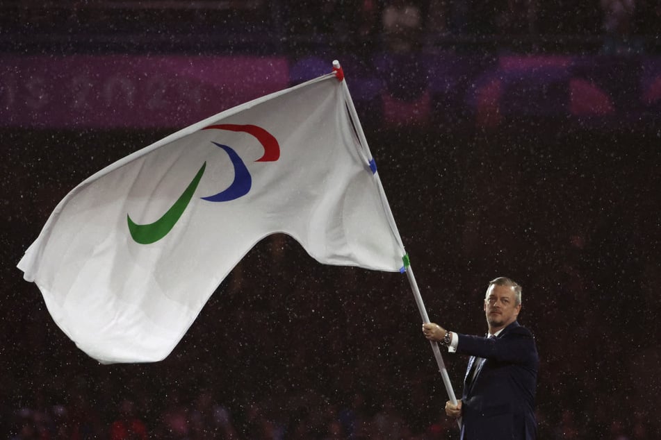 IPC President Andrew Parsons waves the Paralympics flag during the Paris Paralympic Games Closing Ceremony at the Stade de France in Saint-Denis on September 8, 2024.