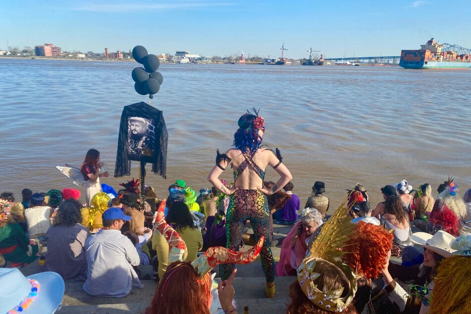 Sarah Zanolli (c. standing) gathered with revelers at the Mississippi River after celebrating Mardi Gras in New Orleans.