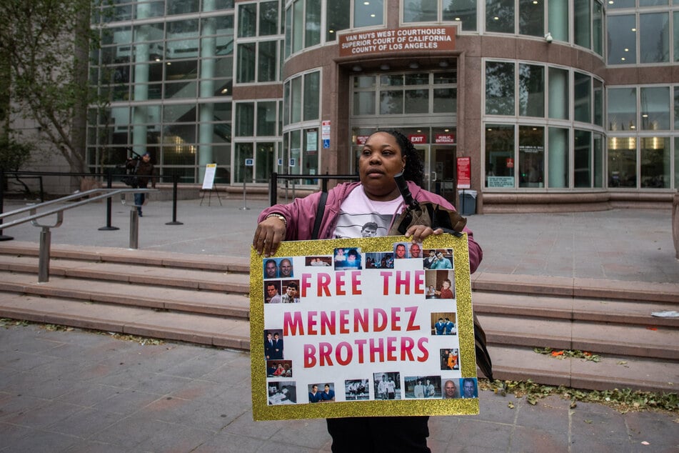 A demonstrator holds a sign supporting the Menendez brothers in front of California's Van Nuys West Courthouse during a resentencing hearing on April 17, 2025.