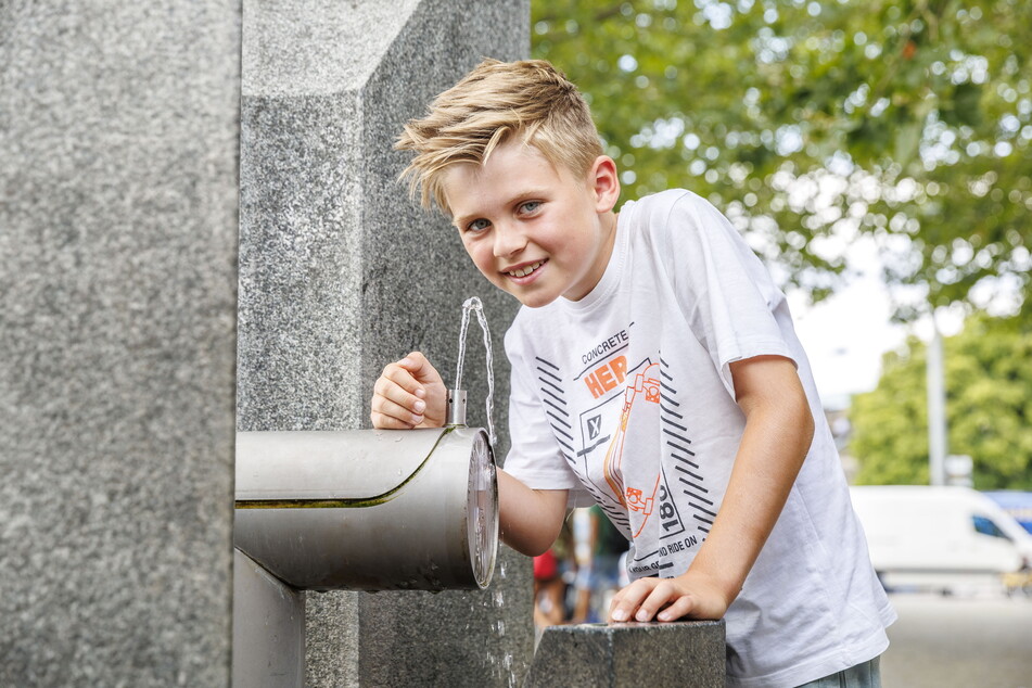 Max (8) aus NRW testet den Trinkwasserbrunnen am Dresdner Postplatz.