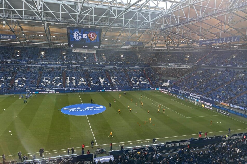 Die Spieler machen sich auf dem Rasen warm.