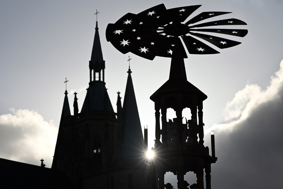 Die Silhouette der Weihnachtspyramide auf dem Domplatz ist neben dem Mariendom zu sehen. Wegen der kritischen Corona-Situation hat die Stadt Erfurt ihren diesjährigen Weihnachtsmarkt abgesagt. (Symbolbild)