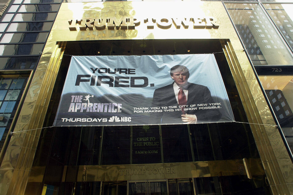 A sign with Donald Trump's image advertising the hit television show The Apprentice hangs from the entrance of Trump Tower on March 19, 2004.