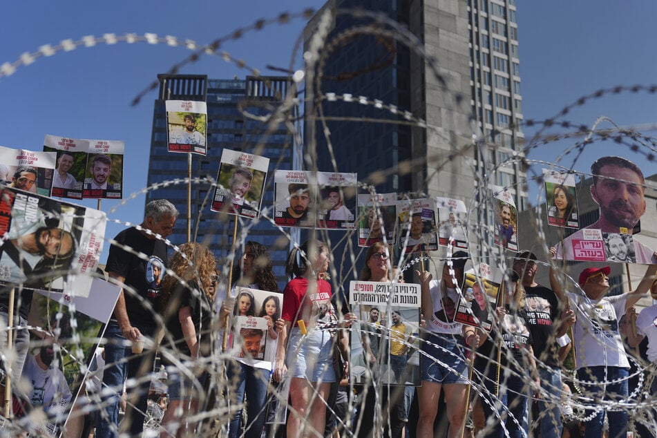 Angehörige israelischer Geiseln haben sich hinter einer Stacheldrahtinstallation in Tel Aviv versammelt.