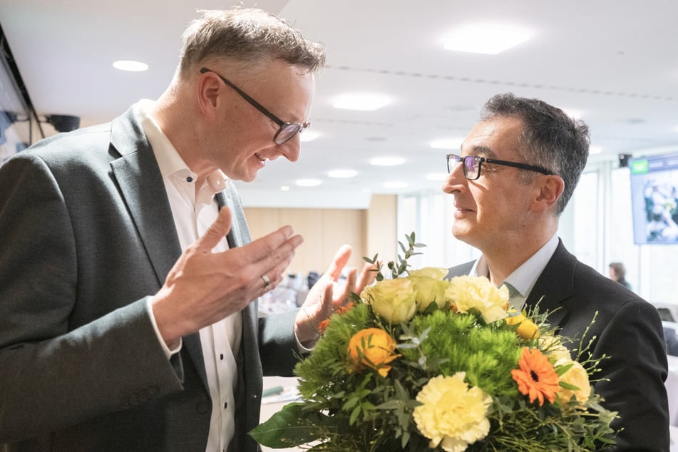 Andreas Schwarz (Bündnis 90/Die Grünen, l.), Fraktionsvorsitzender der Grünen im Landtag von Baden-Württemberg, übergibt im Haus der Abgeordneten in einer Pause einer Fraktionssitzung einen Blumenstrauß an Cem Özdemir.