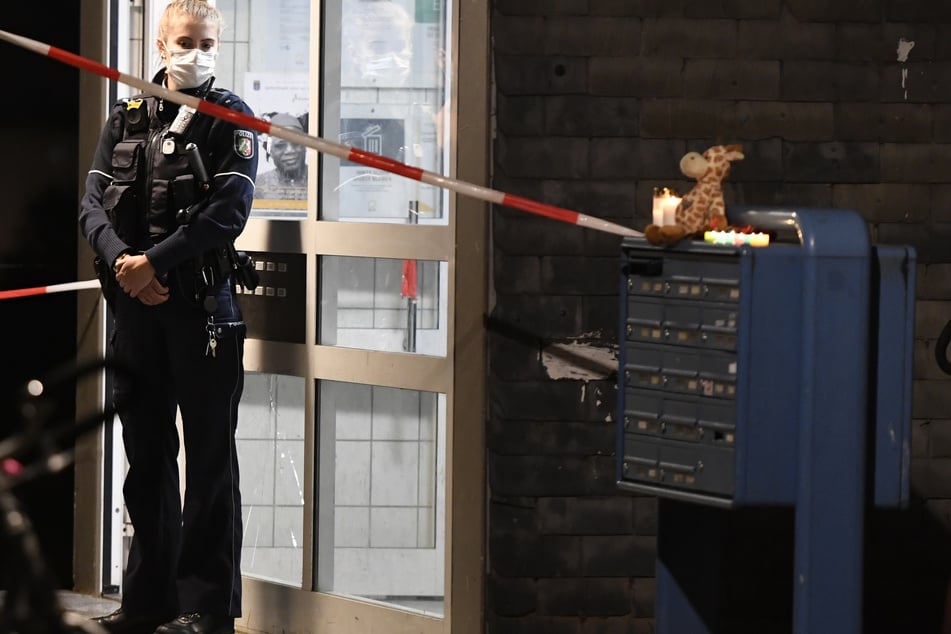 Eine Polizistin steht in Solingen vor dem Hauseingang, hinter dem eine Mutter (27) fünf ihrer Kinder getötet haben soll.
