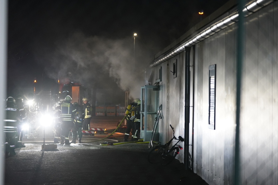 Die Feuerwehr kämpft mit Atemschutz gegen die Flammen. Mehrere Bewohner erlitten durch den dichten Qualm eine Rauchvergiftungen.