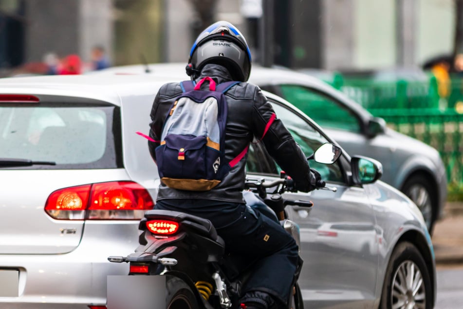 Biker schlägt während Fahrt Scheibe von Audi ein