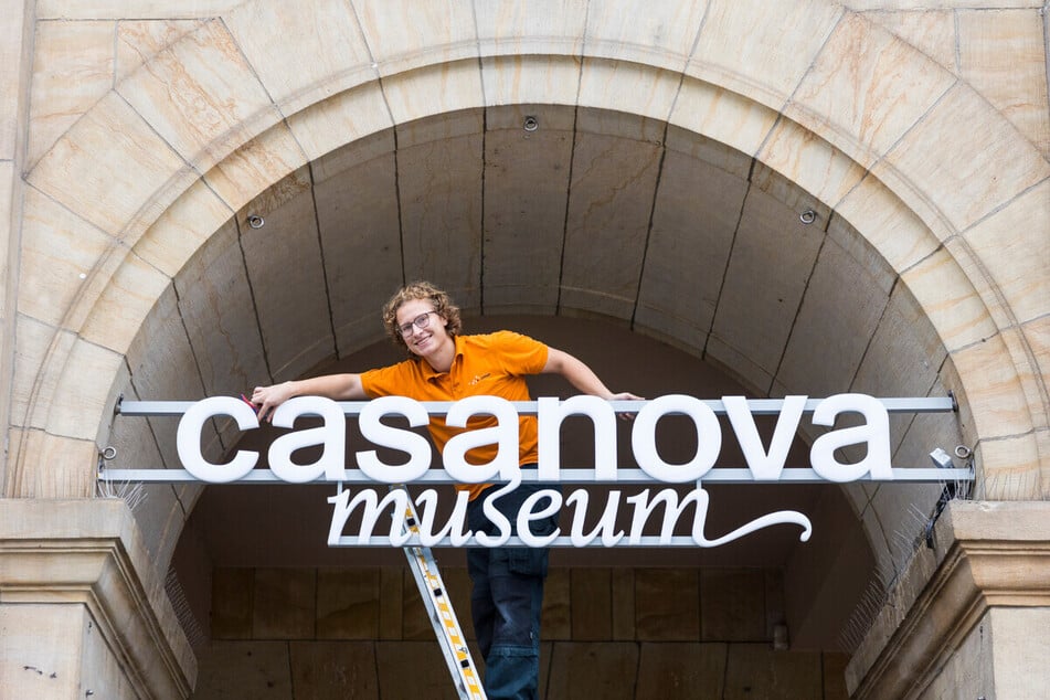 Oskar Hasse (21) befestigt den Museums-Schriftzug an der Altmarkt-Fassade der Galerie.