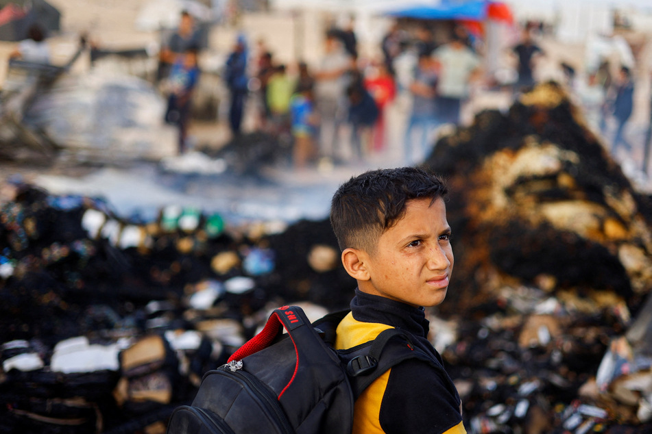 A Palestinian boy looks on at the site of an Israeli strike on a refugee camp in Rafah.