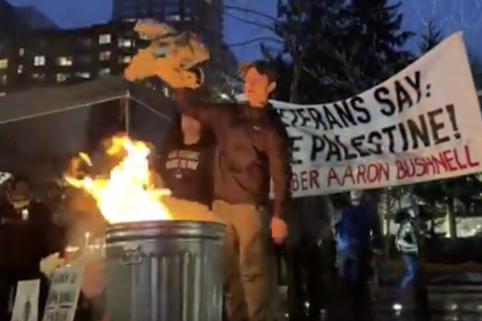 Veterans of the US armed forces toss their uniforms into the flames as they call for Palestinian freedom during a vigil in honor of Aaron Bushnell.