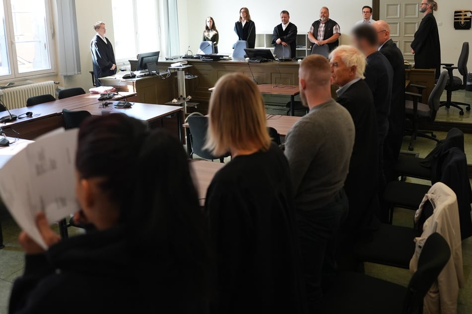 Die Angeklagten standen neben ihren Anwälten zu Beginn des Prozesses wegen erpresserischen Menschenraubs im Sitzungssaal im Strafjustizgebäude.