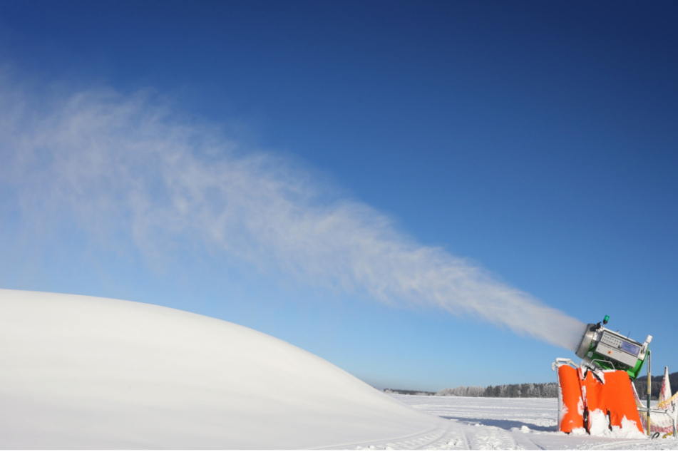 Eine Schneekanone produziert an einer Skipiste am Fuß des Tegelberges Schnee.