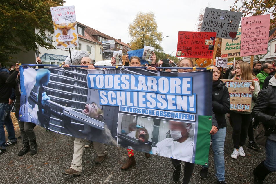 Mit Schildern und Transparenten auf denen auch der Schriftzug "Todeslabore schliessen" zu sehen ist, demonstrieren Teilnehmer in Hamburg-Neugraben gegen Tierversuche. (Archivbild)