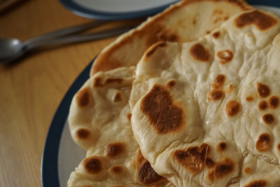 Homemade naan bread in a skillet will be a bit different due to the lack of a tandoori oven, but still delicious.