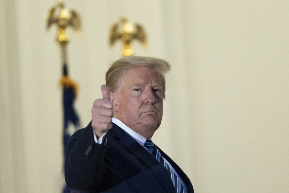 Präsident Donald Trump streckt den Daumen nach oben auf dem Balkon vor dem Blöue Room bei seiner Rückkehr ins Weiße Haus am Montag.