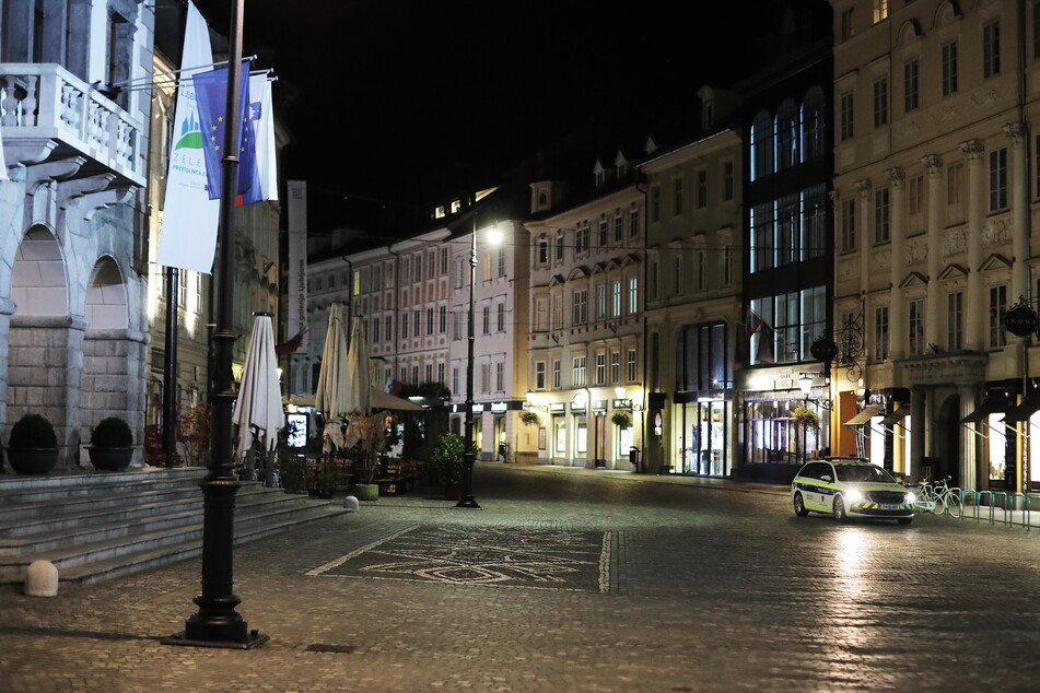 Ein Polizeiauto fährt durch eine menschenleere Straße in Ljubljana. Aufgrund steigender Corona-Zahlen gelten in dem Land ab 15. Juli verschärfte Corona-Regeln.