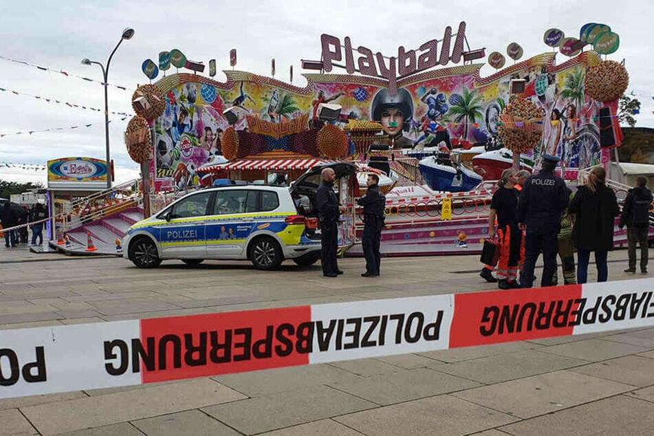 Polizisten und ein Polizeiwagen stehen vor dem Fahrgeschäft "Playball" beim "Potsdamer Oktoberfest".