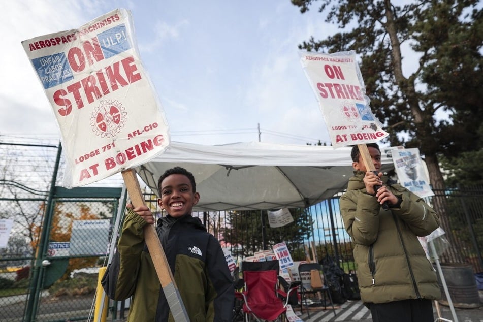 Brothers Noel (r.) and Nahom picket with their mother (not pictured) outside Boeing's Renton Production Facility in Washington one day before striking union members will vote on a new contract offer.