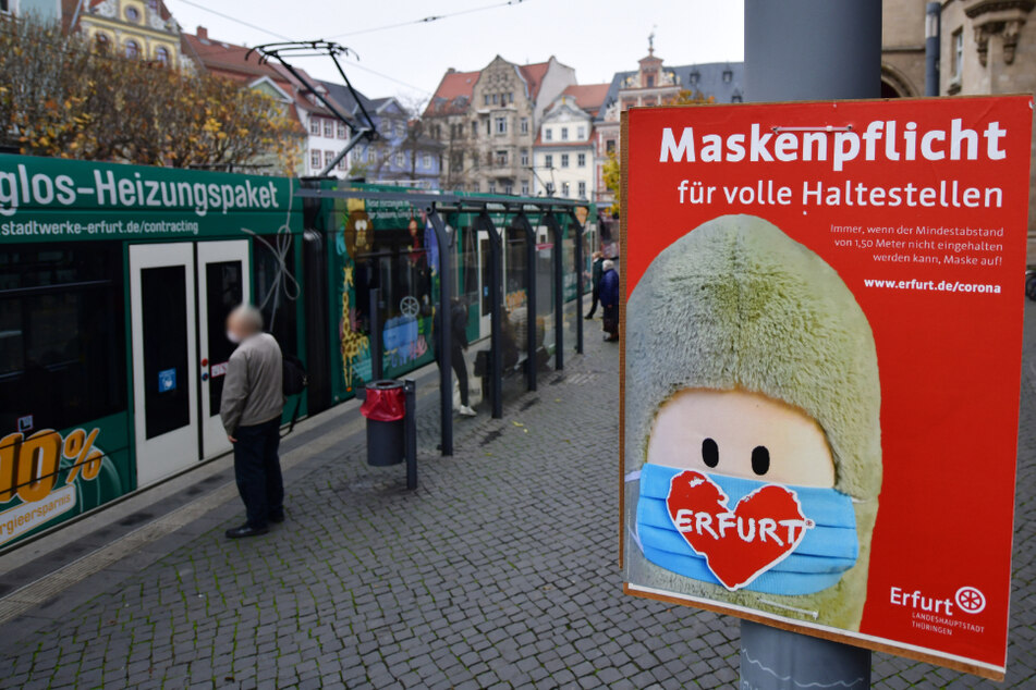 "Maskenpflicht für volle Haltestellen" steht auf einem Plakat der Stadt Erfurt, auf dem auch eine Puffbohne, das Maskottchen der Stadt, zu sehen ist. (Symbolbild)