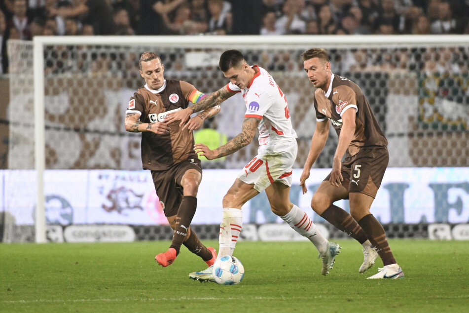 Der FC St. Pauli um Kapitän Jackson Irvine (l.) und Hauke Wahl (r.) treffen zum dritten Mal in dieser Saison auf RB Leipzig und Stürmerstar Benjamin Sesko.