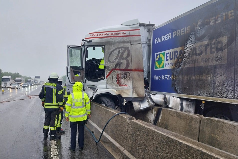 Einsatzkräfte sichern die Unfallstelle auf der A3 bei Bad Honnef, während der Verkehr nur eingeschränkt an der Unglücksstelle vorbeikommt.