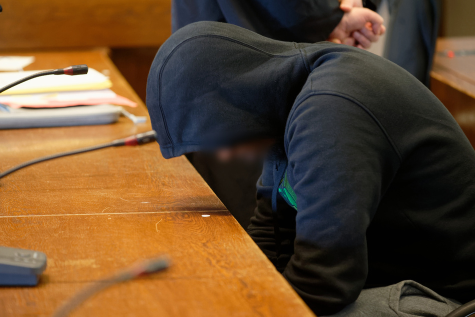 Der Angeklagte sitzt zum Beginn seines Prozesses in einem Saal des Landgerichts. Der 26-Jährige soll einen Mann am Kölner Ebertplatz durch einen Stich in den Hals getötet haben.