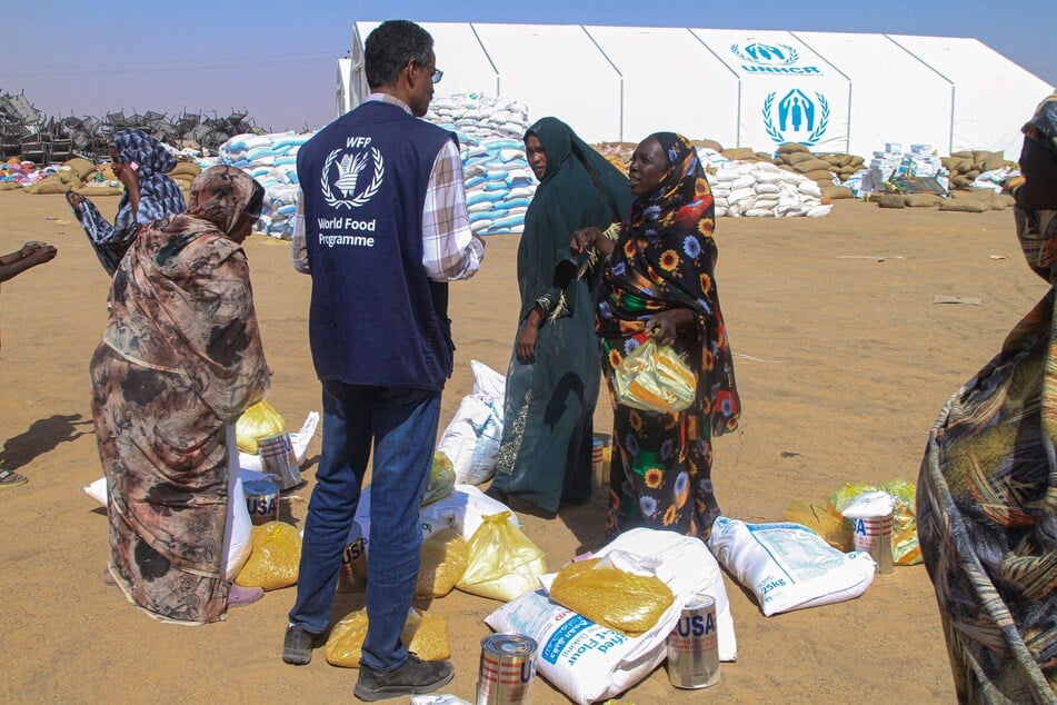 Sudanese women who fled El-Fasher receive humanitarian aid at the Al-Afad camp for displaced people in the town of Al-Dabba in northern Sudan on November 25, 2025.