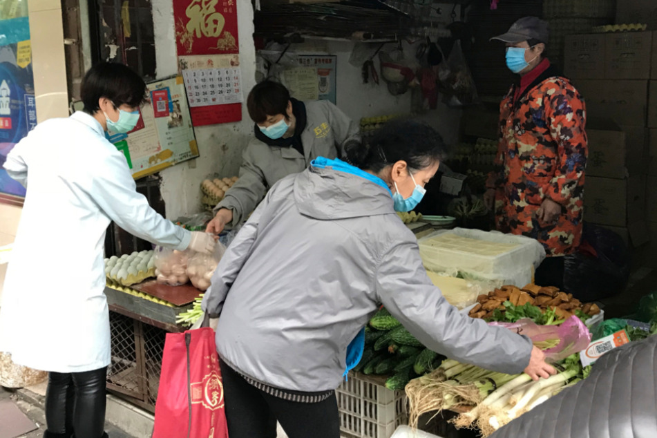 Bewohner der chinesischen Stadt Wuhan kaufen Gemüse in einem Laden.
