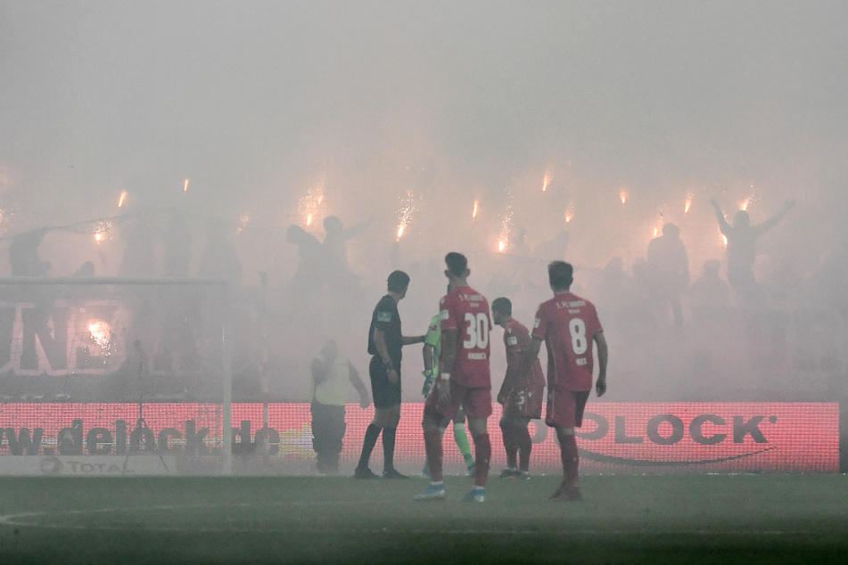 Hertha-Fans nebeln die Alte Försterei ein. Schiedsrichter Deniz Aytekin (l.) musste die Partie unterbrechen.